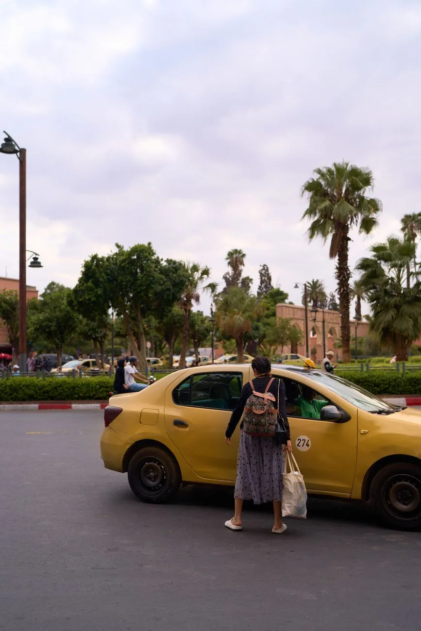 Petit taxi jaune à l’arrêt dans une avenue bordée de palmiers, au Maroc