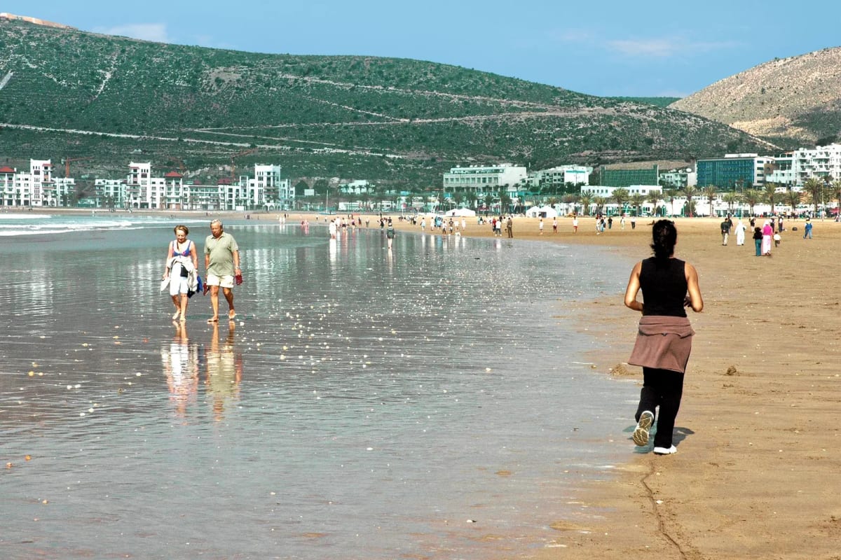 Baie d’Agadir vue depuis la plage, colline et ville blanche en arrière-plan