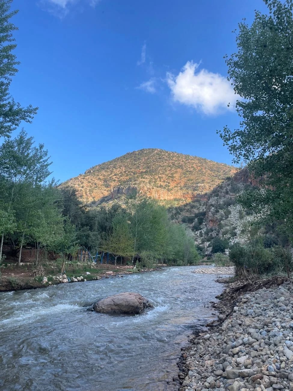 Rivière de montagne coulant entre les berges caillouteuses de la vallée de l’Ourika