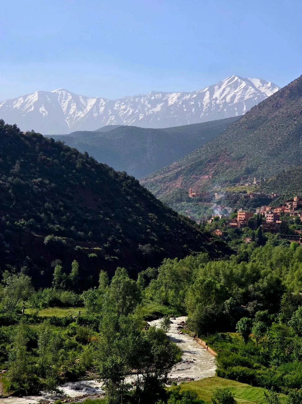 Sommets enneigés du Haut Atlas dominant une vallée verte, au Maroc