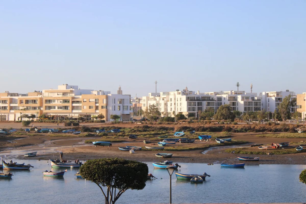 Résidences récentes au bord du Bouregreg à Rabat, barques de pêche échouées à marée basse au premier plan