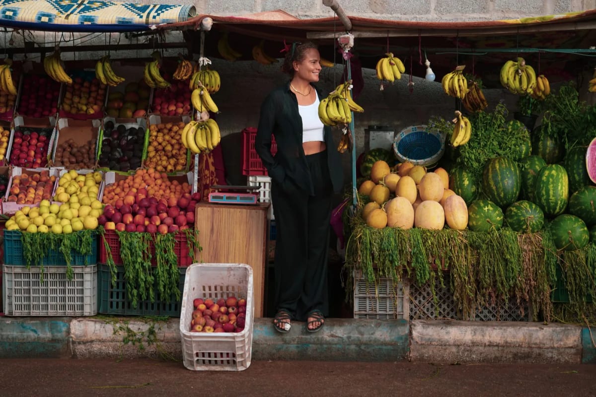 Étal de fruits et légumes tenu par une marchande dans un marché marocain