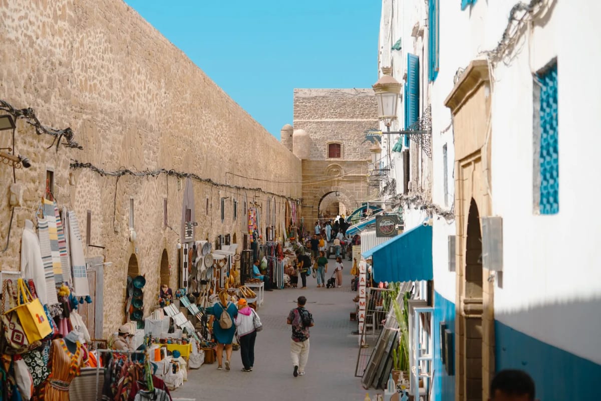 Ruelle blanche et bleue de la médina d’Essaouira, boutiques d’artisanat le long des remparts