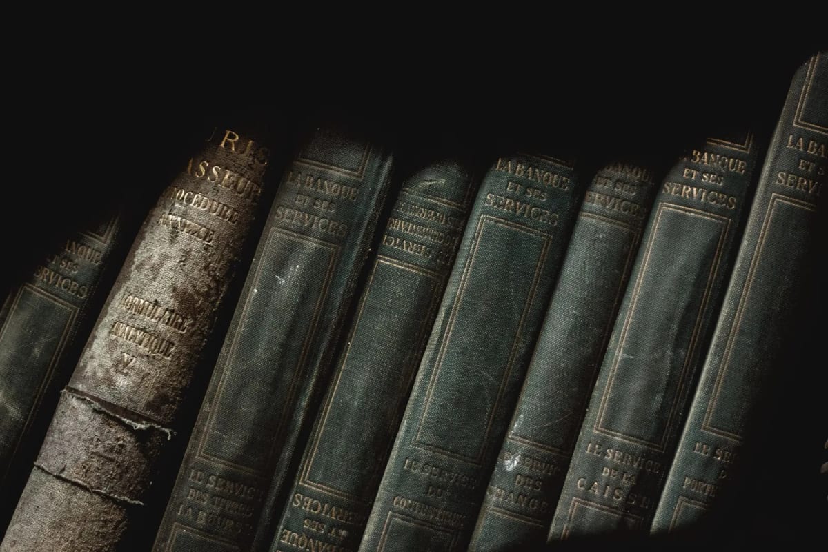 Tranches de vieux livres reliés alignés sur une étagère