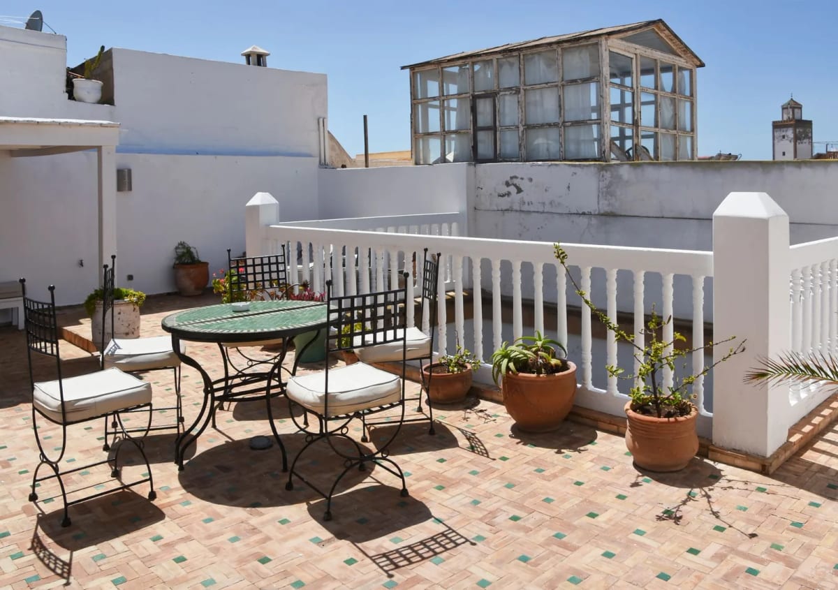 Terrasse de toit meublée avec des plantes en pot, maison au Maroc
